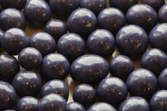 Blueberries covered a chocolate candied confection. 